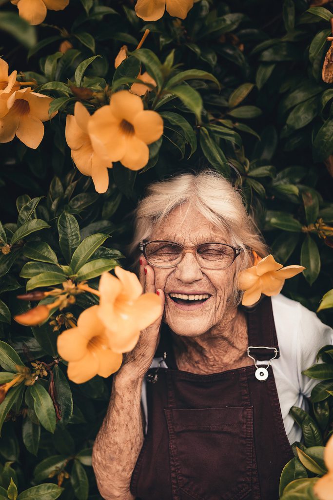 Vrouw tussen struik met bloemen